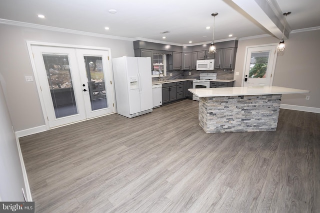 kitchen featuring hardwood / wood-style floors, white appliances, sink, hanging light fixtures, and gray cabinets