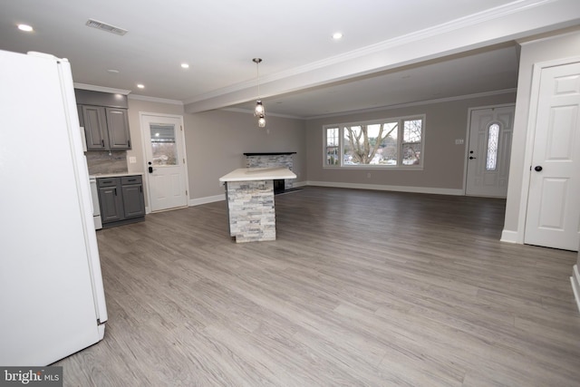 kitchen featuring gray cabinets, white fridge, light hardwood / wood-style floors, and ornamental molding