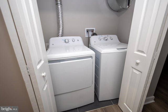 clothes washing area with separate washer and dryer and dark hardwood / wood-style flooring