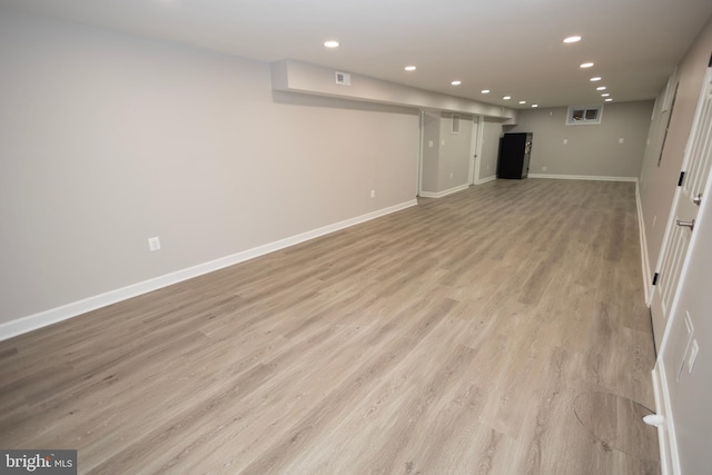 basement with light hardwood / wood-style floors