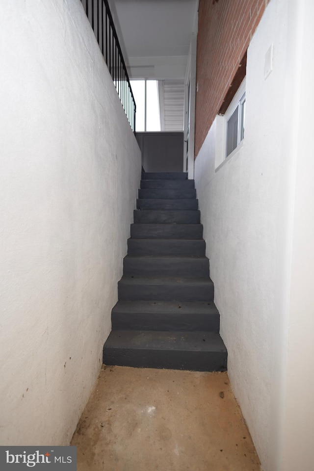 stairs featuring concrete flooring