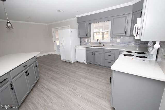 kitchen featuring pendant lighting, gray cabinetry, white appliances, sink, and light wood-type flooring