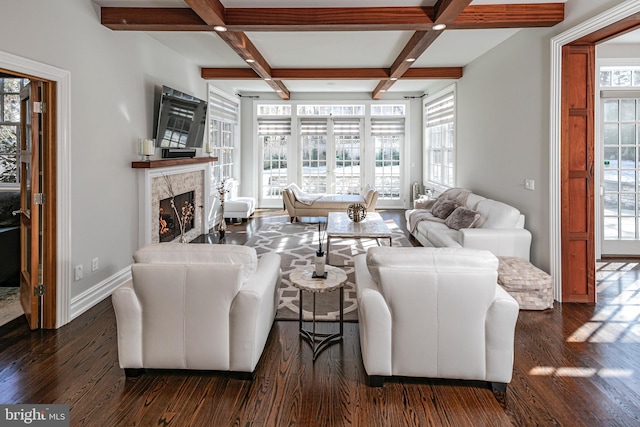 living area with a premium fireplace, dark wood-style flooring, coffered ceiling, baseboards, and beam ceiling