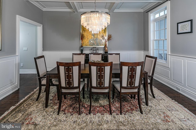 dining area with a chandelier, ornamental molding, and dark wood-style flooring