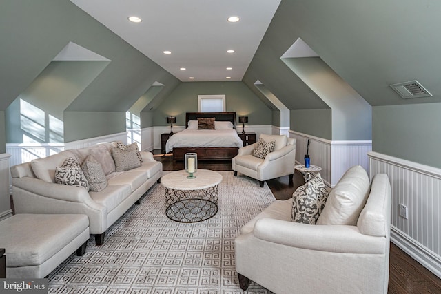 bedroom with recessed lighting, lofted ceiling, visible vents, wainscoting, and wood finished floors