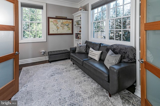 living room with ornamental molding, baseboards, and wood finished floors