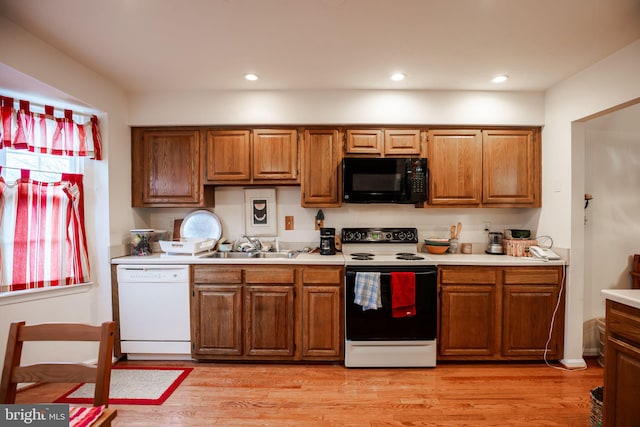 kitchen with white appliances, light hardwood / wood-style flooring, and sink