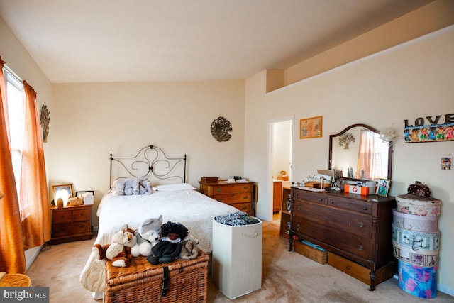 bedroom featuring light colored carpet and lofted ceiling