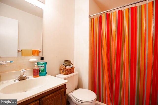 bathroom featuring a shower with curtain, vanity, and toilet