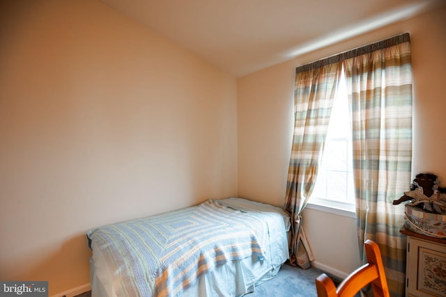 carpeted bedroom with lofted ceiling