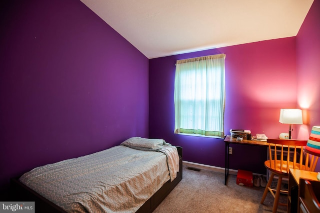 bedroom with carpet flooring and lofted ceiling