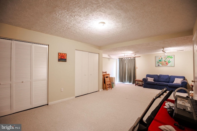 unfurnished bedroom featuring a textured ceiling, carpet flooring, and two closets