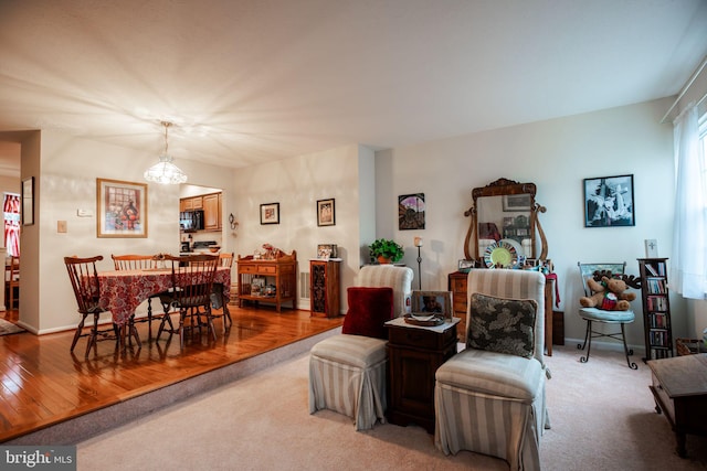 living room with an inviting chandelier and light hardwood / wood-style flooring