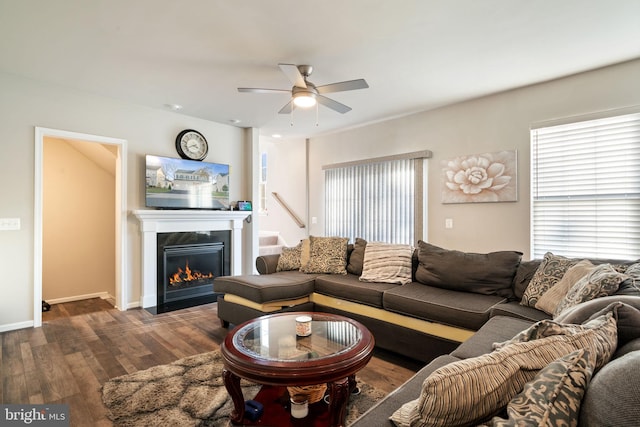 living room featuring ceiling fan and dark wood-type flooring