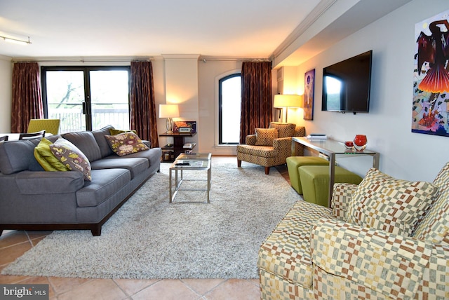 living room with light tile patterned floors, crown molding, and a healthy amount of sunlight