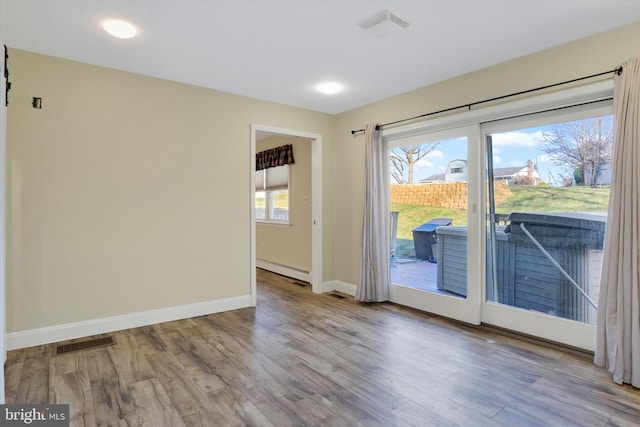 spare room featuring light hardwood / wood-style flooring and a baseboard heating unit