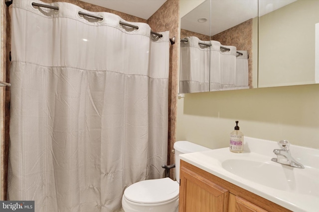 bathroom featuring vanity, toilet, and curtained shower