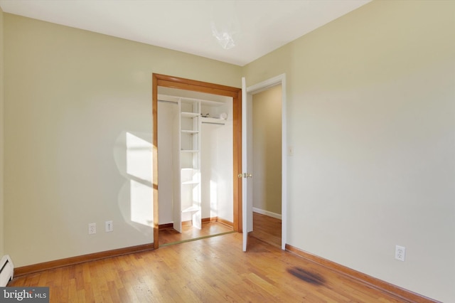 unfurnished bedroom featuring light hardwood / wood-style floors and a baseboard radiator