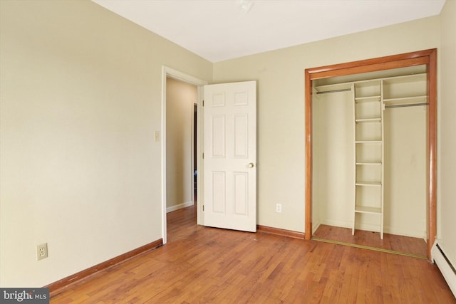 unfurnished bedroom featuring light hardwood / wood-style floors and a baseboard radiator