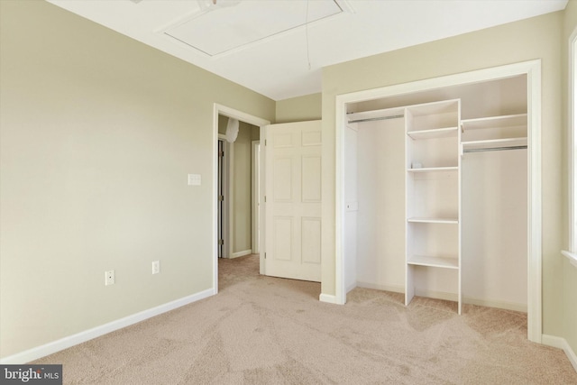 unfurnished bedroom with light colored carpet and a closet