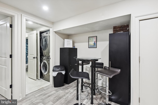 office featuring stacked washing maching and dryer and light wood-type flooring