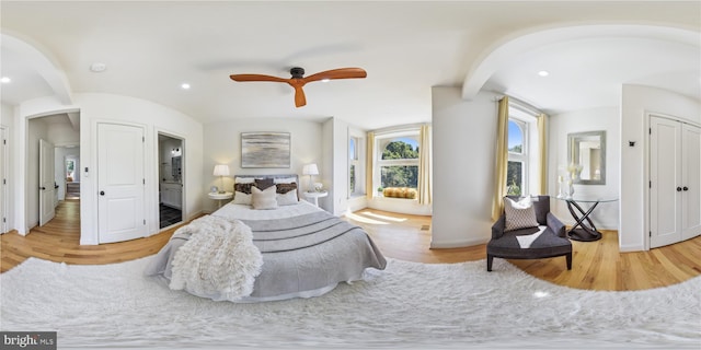 bedroom featuring ceiling fan, connected bathroom, and light hardwood / wood-style flooring