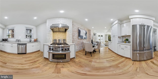 kitchen with white cabinets, appliances with stainless steel finishes, light hardwood / wood-style flooring, and a healthy amount of sunlight