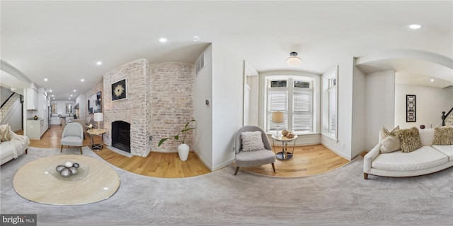 interior space featuring a brick fireplace and hardwood / wood-style flooring