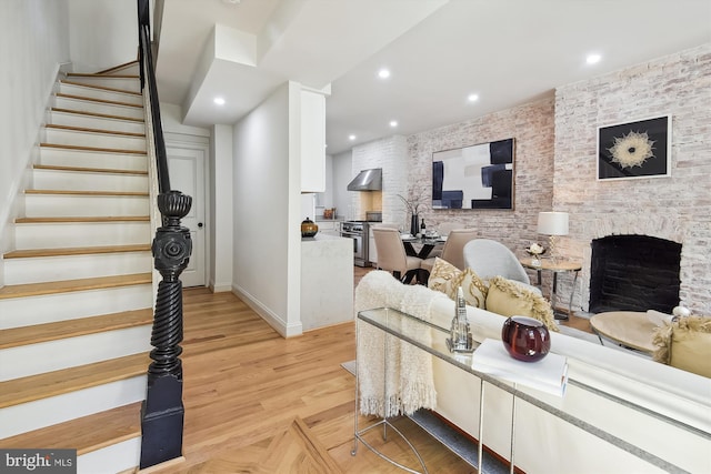 living room with light wood-type flooring and a stone fireplace