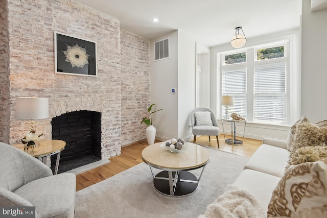 living room featuring a large fireplace and wood-type flooring