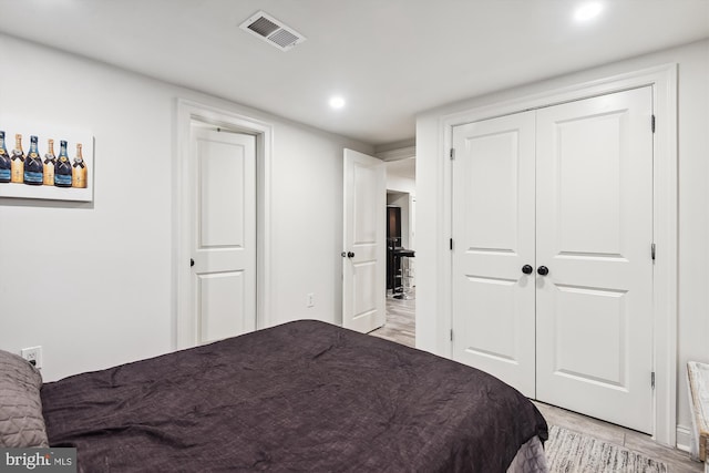 bedroom with bar area, light hardwood / wood-style floors, and a closet