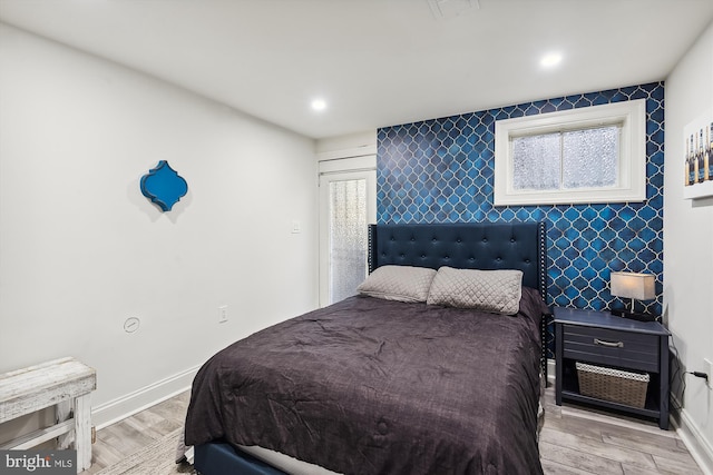 bedroom featuring light hardwood / wood-style flooring and tile walls