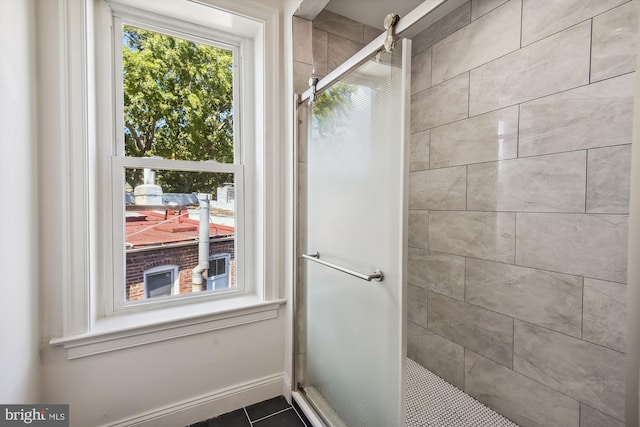 bathroom with a tile shower and tile patterned flooring