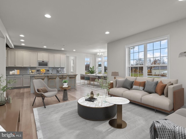 living room featuring an inviting chandelier and light wood-type flooring