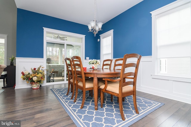 dining space featuring dark hardwood / wood-style floors and an inviting chandelier