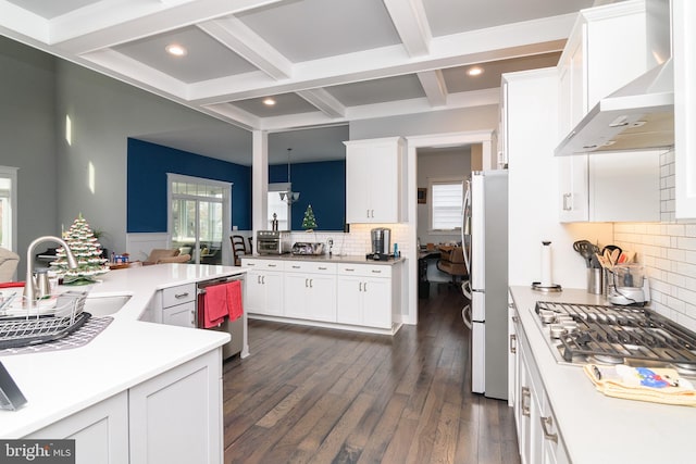 kitchen featuring backsplash, wall chimney exhaust hood, coffered ceiling, dark wood-type flooring, and white cabinetry