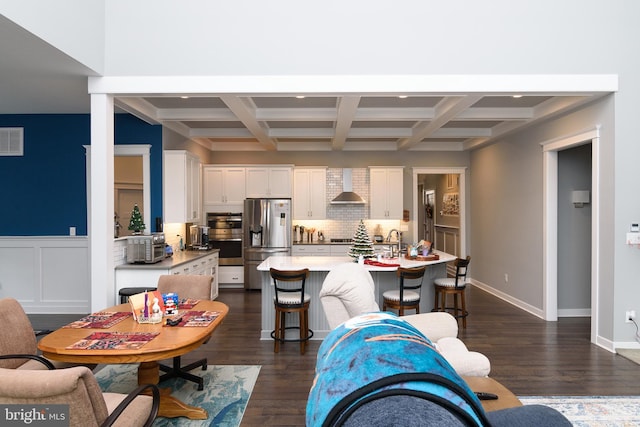 dining area with dark hardwood / wood-style floors, beam ceiling, and coffered ceiling