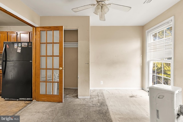 interior space with french doors, light colored carpet, and ceiling fan