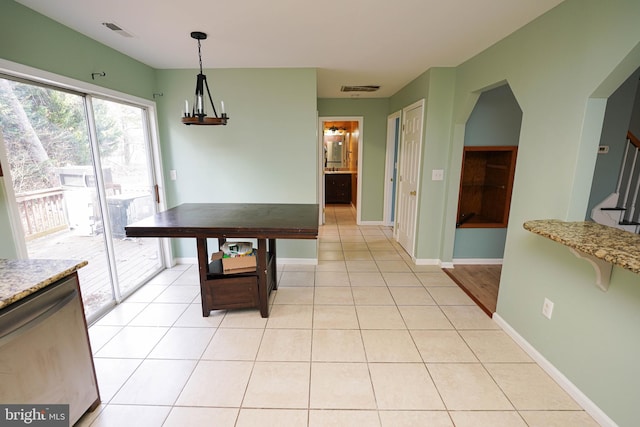 dining area featuring light tile patterned floors and a notable chandelier