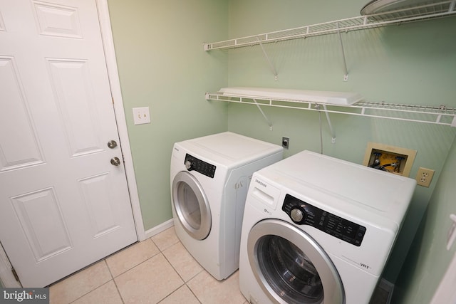 washroom with washer and clothes dryer and light tile patterned floors