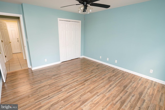 unfurnished bedroom with a closet, light hardwood / wood-style floors, and ceiling fan