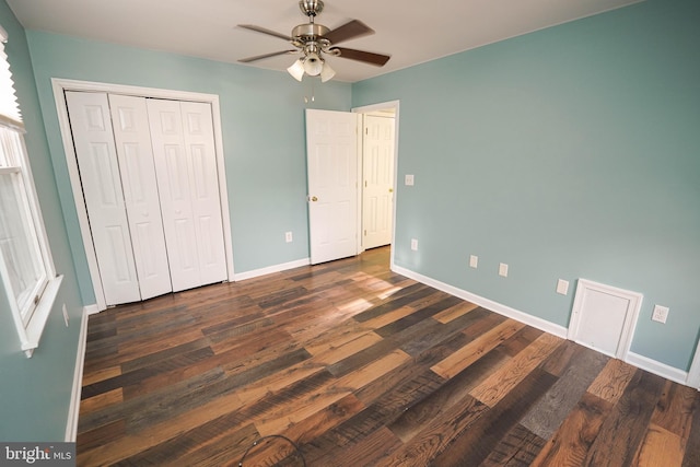 unfurnished bedroom with ceiling fan, a closet, and dark wood-type flooring