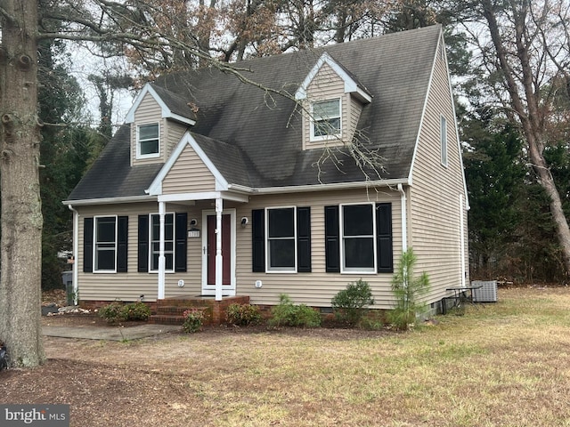 cape cod home with cooling unit and a front yard