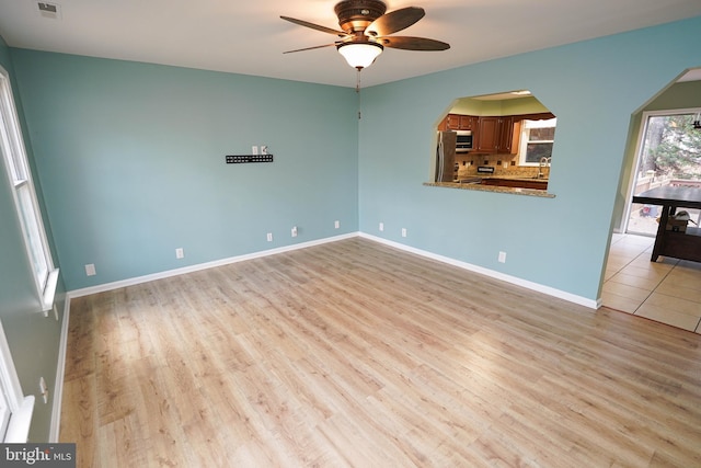 unfurnished room with ceiling fan, sink, and light hardwood / wood-style floors