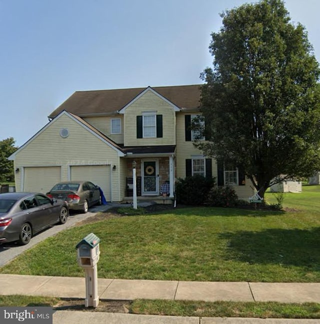 view of property featuring a front lawn and a garage