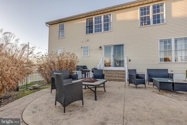 back of property featuring a patio area and an outdoor living space with a fire pit