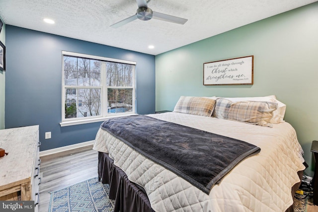 bedroom featuring a textured ceiling, light hardwood / wood-style floors, and ceiling fan