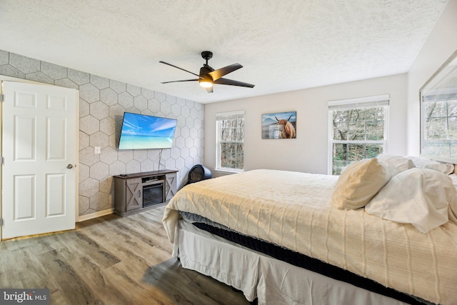 bedroom featuring ceiling fan, a textured ceiling, and light hardwood / wood-style flooring