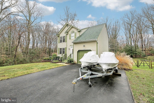 view of side of property featuring a garage and a yard