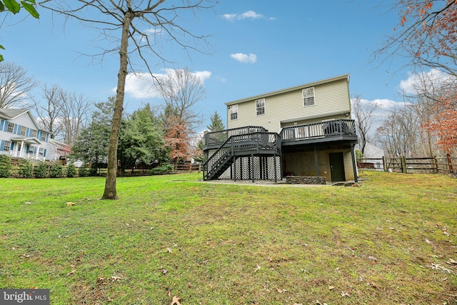 rear view of house with a lawn and a wooden deck